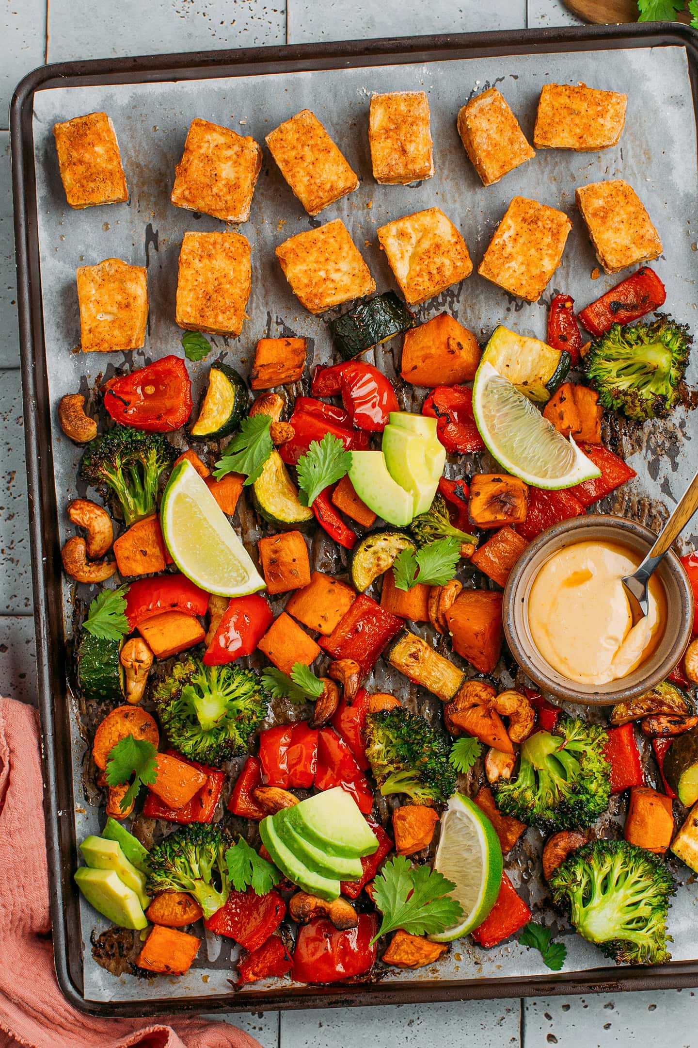 Sheet pan loaded with roasted sweet potatoes, broccoli, red bell pepper, and tofu.