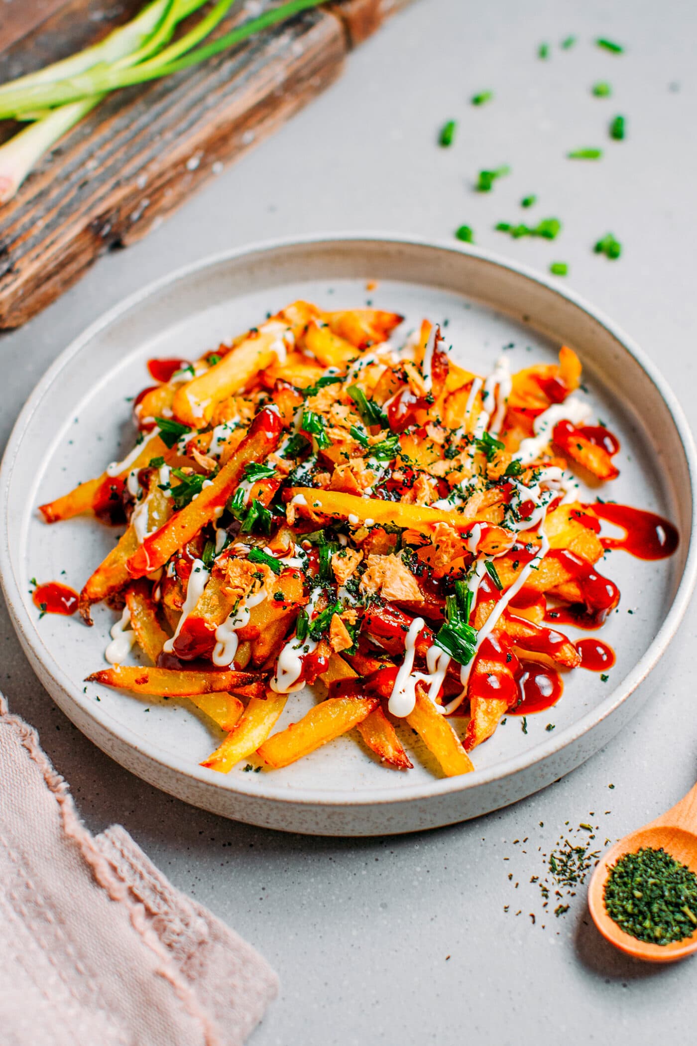 Vegan french fries topped with okonomiyaki sauce, mayo, aonori, and green onions.
